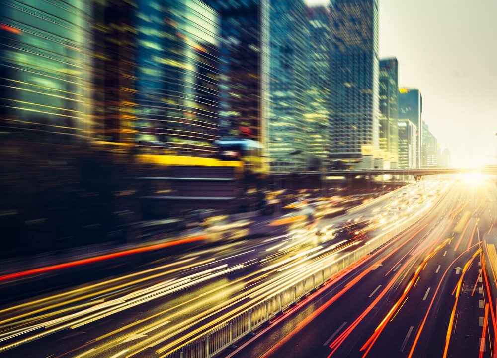 Motion light trails through a city — momentum forward